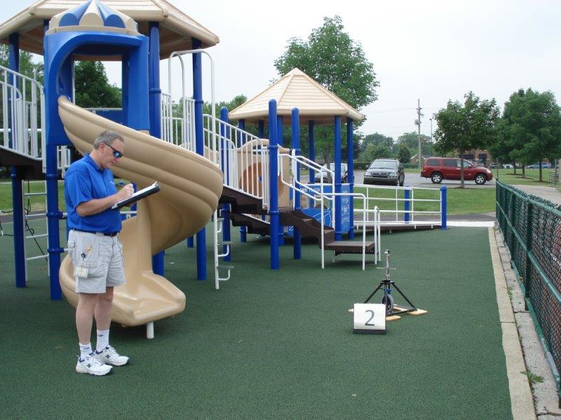 A playground owner records the findings after installation of the new poured-in-place rubber surface.