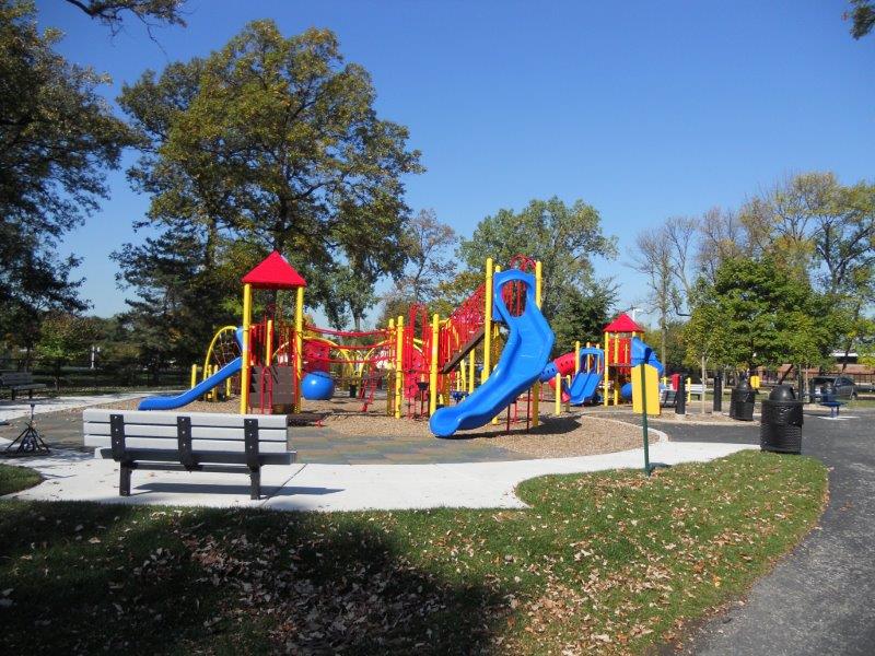 A composite play structure surfaced with poured in place rubber and engineered wood fiber.