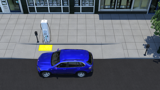 A blue SUV parked on the street beside a flush access aisle and wide sidewalk. EV charger is installed on the sidewalk curb facing the access aisle. A yellow rectangle on the access aisle indicates clear floor space for the charger.