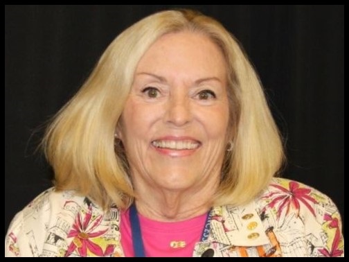 Headshot of Jan Tuck wearing a white and pink floral shirt with a pink undershirt.