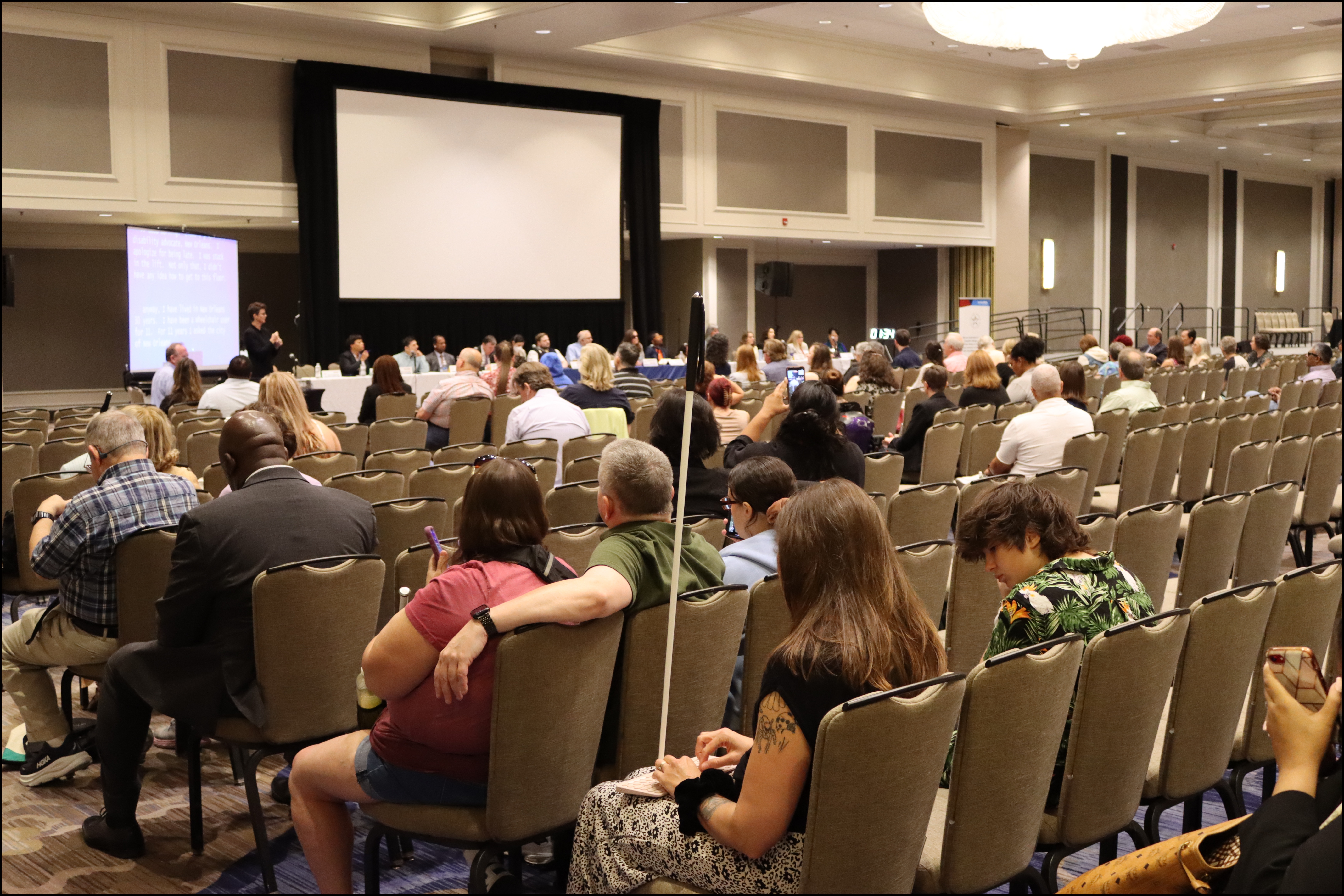 The audience sits in attendance at the town hall.